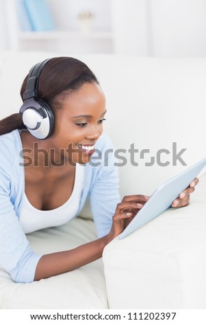 Black woman using a tablet computer in a living room