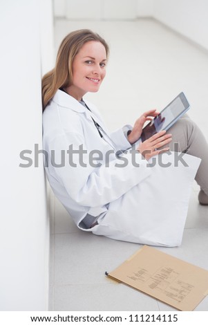 Doctor using an book while sitting in hospital ward