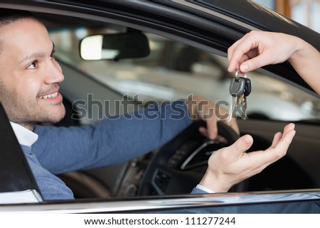 Man receiving keys while sitting in a car