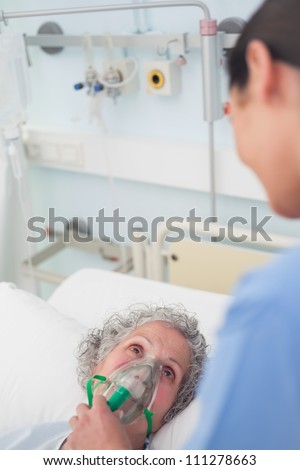 Patient having an oxygen mask on her face in hospital ward