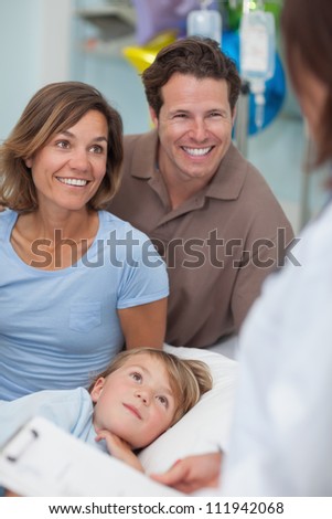 Parents and child looking at a doctor in hospital ward