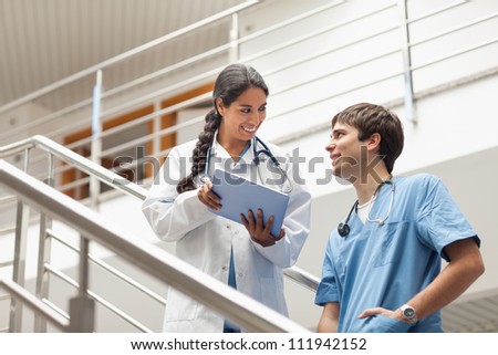 Female doctor holding a tablet computer on stairs in hospital