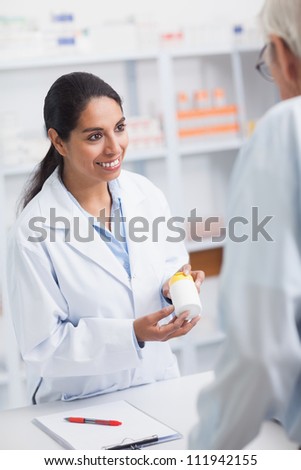 Pharmacist showing a drug box to a old man in a hospital