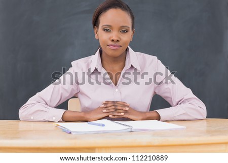 Front view of a black teacher looking at camera in a classroom