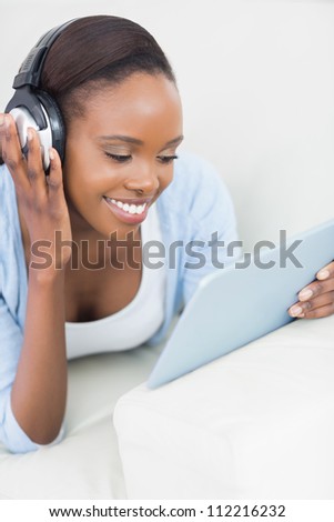 Black woman looking at a tablet computer in a living room