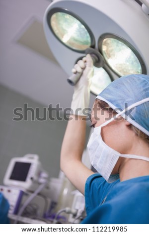 Nurse moving the surgical light in operating theater