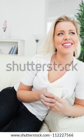 Woman drinking coffee while sitting on a sofa