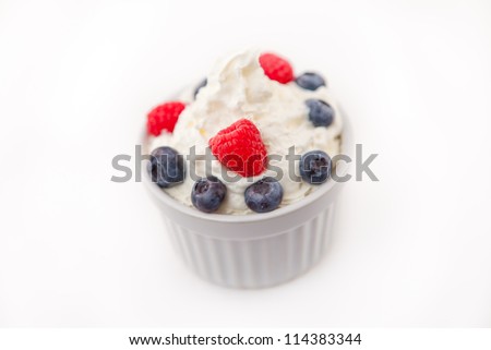 Jar of fruits and whipped cream against white background