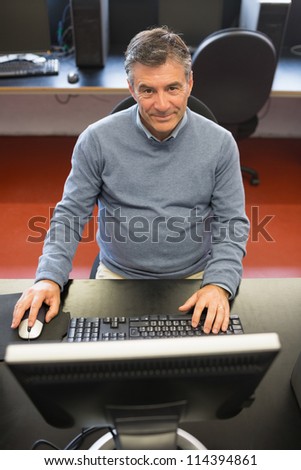 Happy man in computer class using the computer
