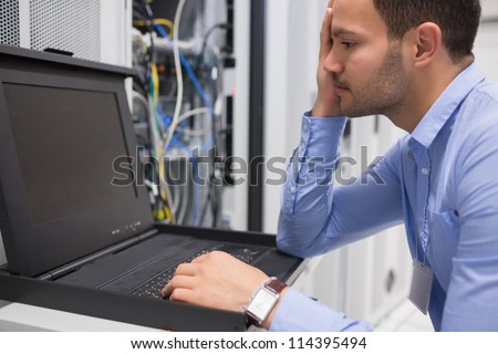 Man running diagnostics of servers in data center