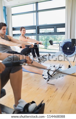 Woman looking up from rowing machine workout in fitness studio
