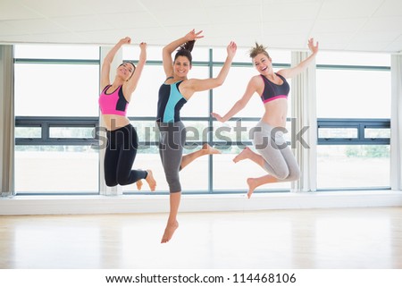 Women jumping in fitness studio at the gym