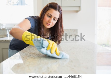 Concentrated Woman Scrubbing The Bar In Kitchen