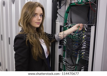 Girl working on mounted rack servers in data storage facility
