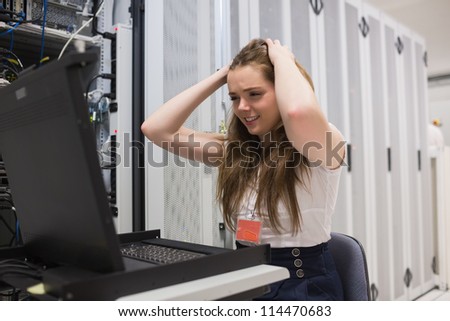 Stressed woman working on the server in data center