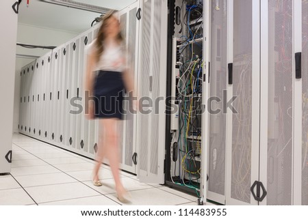 Woman walking through data center beside servers