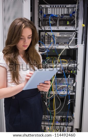 Woman checking servers using tablet pc in data center