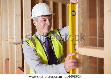 Architect measuring the wood frame with a spirit level