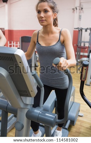 Brunette stepping on a step machine in gym