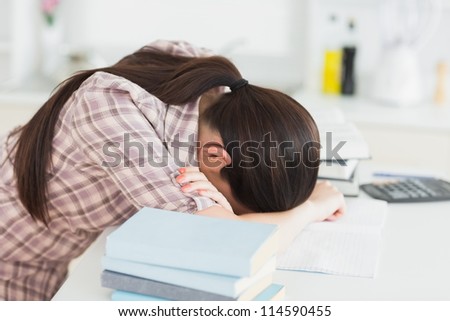 Sleepy woman leaning her head on the table in a living room