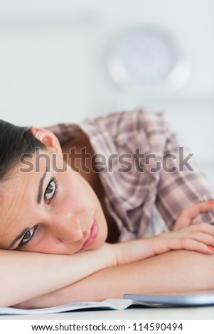 Woman leaning on the table with arms crossed in living room