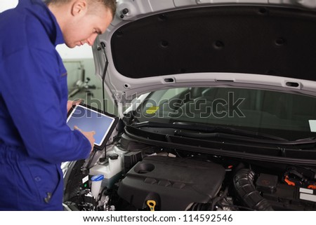 Mechanic using a tablet computer in a garage