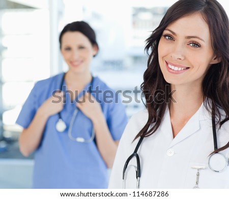 Young Smiling Nurse Standing Upright While Leaning Her Head To The Side