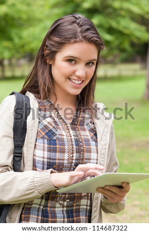 Portrait of a first-year student using a touch pad in a park