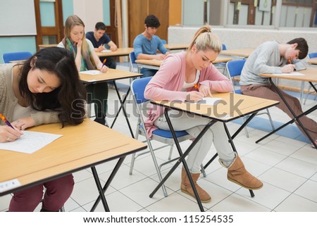 People sitting at the classroom and writing writing