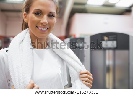 Smiling woman holding a towel in gym