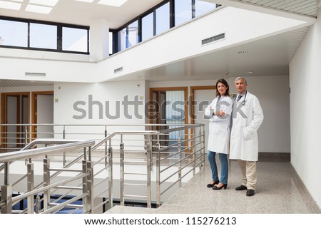 Two doctors standing in the corridor looking at the camera