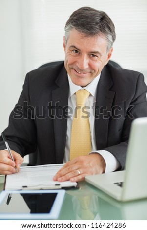 Business man smiling while working in his office