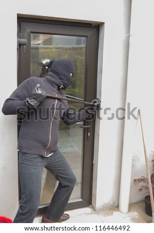 Burglar breaking door from outside with crow bar