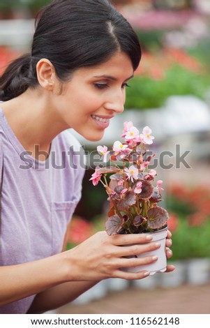 Woman holding a flower and smelling on the flower