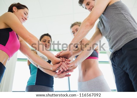 People standing putting hands together at the gym