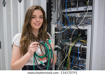 Happy woman holding server wires in data center