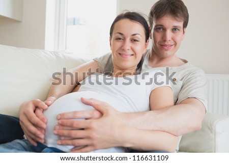 Couple expecting a newborn lying on the couch and relaxing