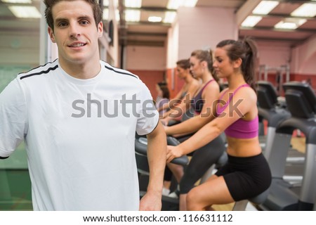 Male smiling in the gym wearing white t-shirt