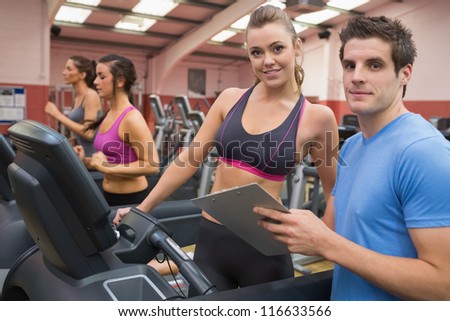 Gym Instructor and woman in the gym on the treadmill