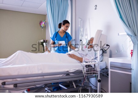 Female doctor consoling female senior patient in the ward at hospital