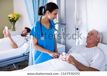 Male doctor examining female senior patient in the ward at hospital