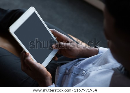 Male executive using digital tablet in futuristic office