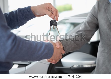 People shaking each other hands while holding keys