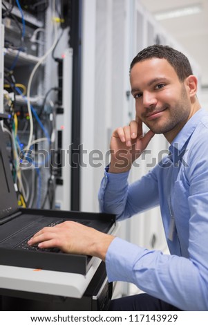 Happy man working with servers in data center