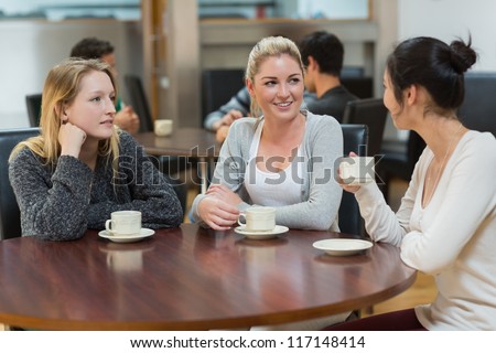 Students talking together in college coffee shop and smiling