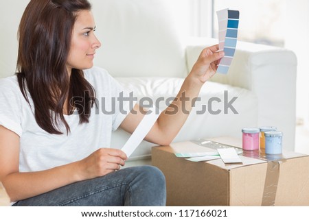 Woman choosing colour for painting the wall