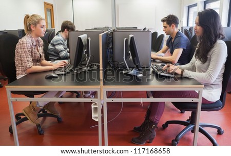 People typing in computer class in college