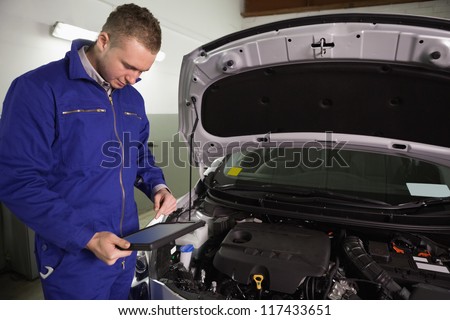 Mechanic looking at a tablet computer in a garage