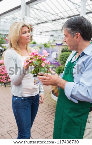 Employee talking to customer about plant in garden center