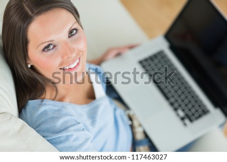 Smiling woman in front of her laptop in the living room